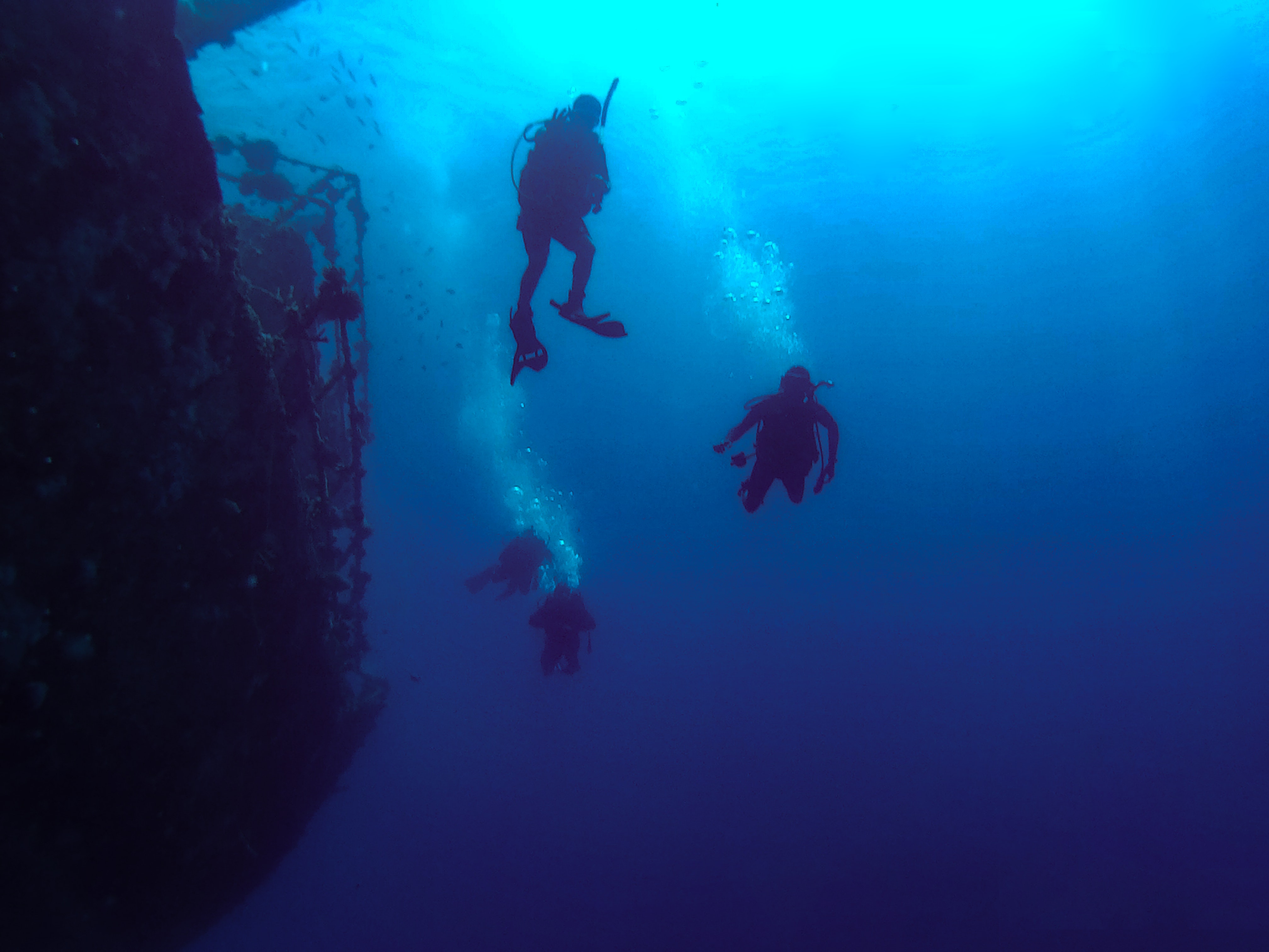 divers next to ship wreck